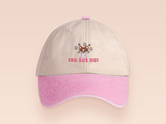 Vintage style truckers baseball cap with a contrast cream and pink peak design with an embroidered cute hanster angry and sulking with the quote smol but angy