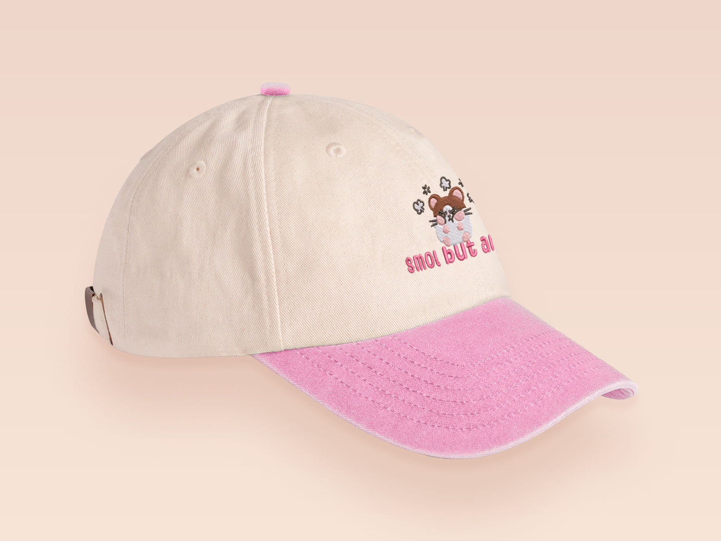 Vintage style truckers baseball cap with a contrast cream and pink peak design with an embroidered cute hanster angry and sulking with the quote smol but angy