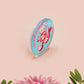 A clear acrylic pin badge with a pink heart-shaped pin back clasp. The design of the pin badge is of a cute chibi shrimp in a chefs outfit cooking with the quote So you're telling me a shrimp fried this rice?