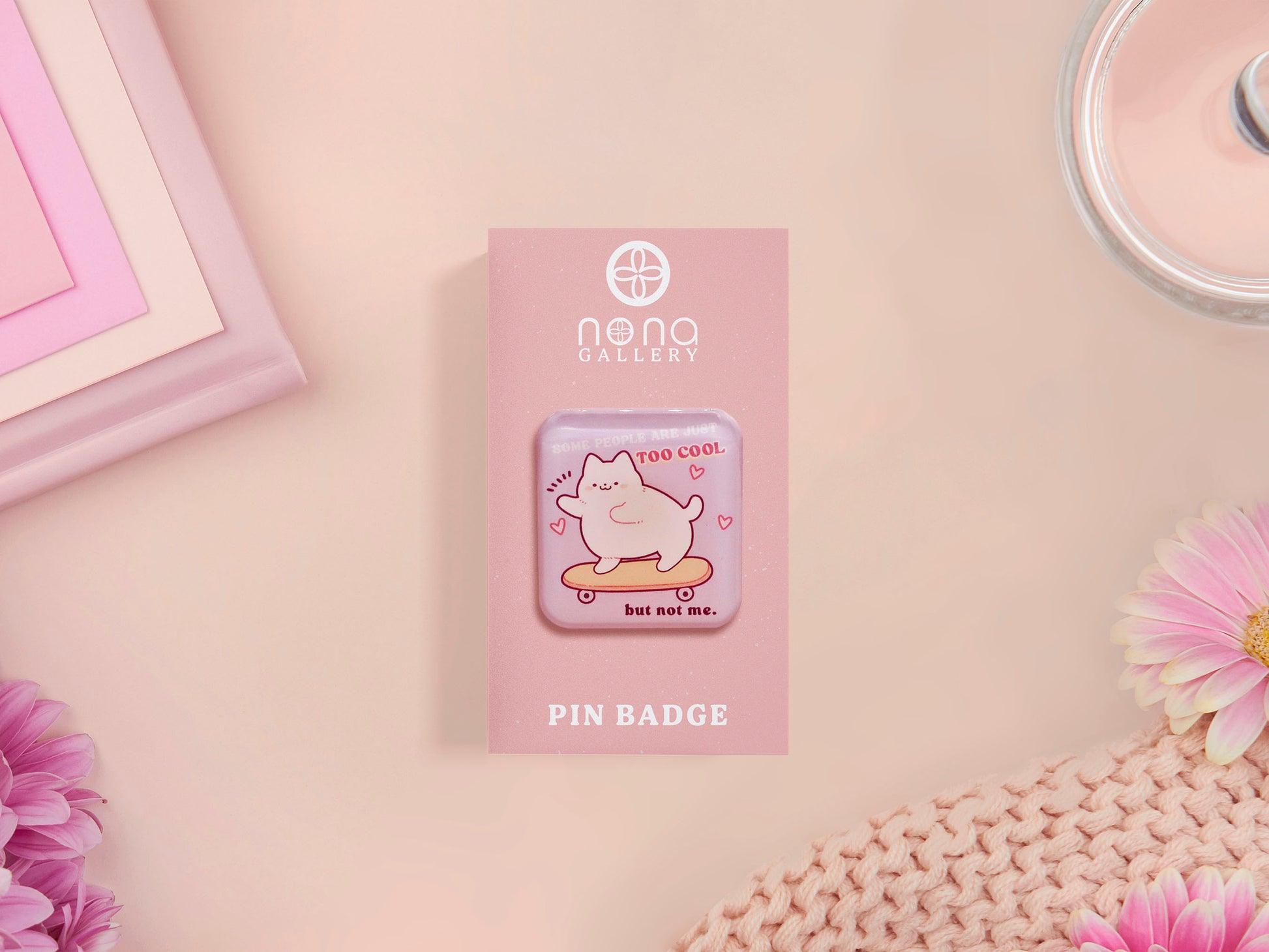 Clear acrylic pin badge with a pink heart-shaped rubber pin back clasp. The design of the pin badge is a cute chibi white cat skateboarding with the quote some people are just too cool but not me.