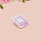 Clear acrylic pin badge with a pink heart-shaped rubber pin back clasp. The design of the pin badge is a cute chibi white cat skateboarding with the quote some people are just too cool but not me.