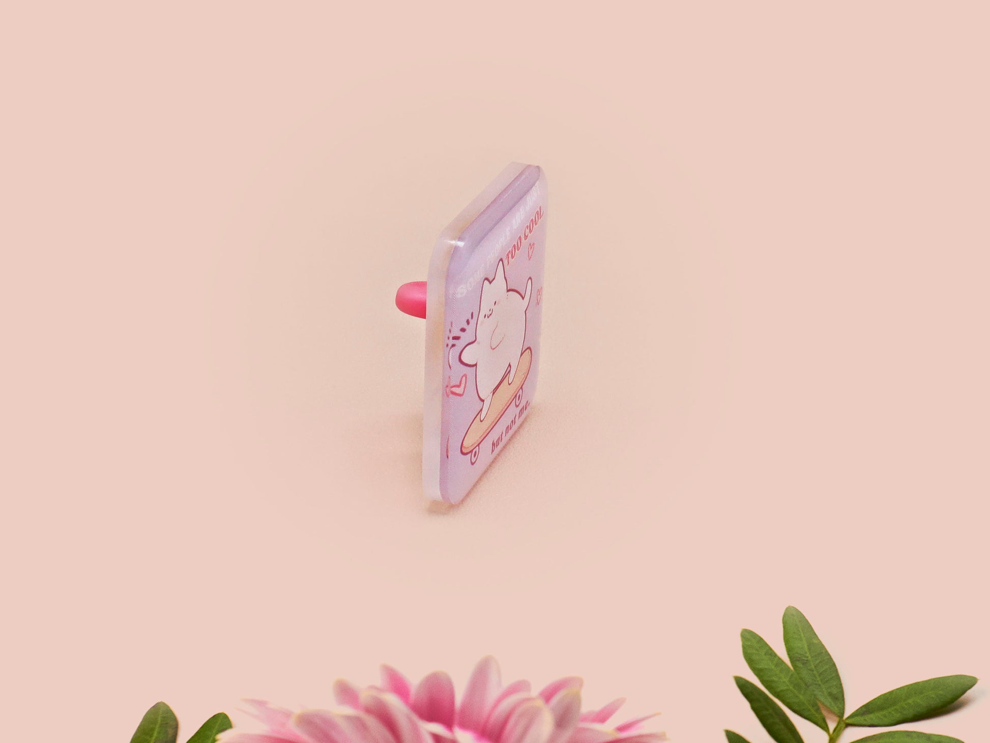 Clear acrylic pin badge with a pink heart-shaped rubber pin back clasp. The design of the pin badge is a cute chibi white cat skateboarding with the quote some people are just too cool but not me.