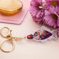 A large transparent acrylic shaker keychain with gold keyring, shaped like a traditional cute chibi soy sauce fish bottle and filled with liquid black gliter and confetti 