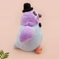 An adorable purple and blue pigeon bird plushie toy with cute embroidered eyes and facial expression, wearing a black top hat and bow tie, with a hang tag describing the pigeon as Susan.