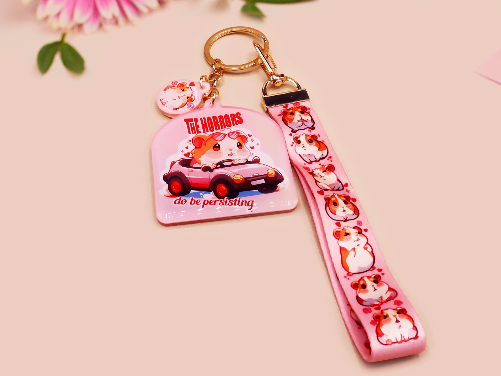 Cute pink keychain and lanyard of an adorable chibi hamster guinea pig in heart sunglasses driving a little pink car with the quote the Horrors do be persisting, with matching mini charm and lanyard of multiple cute fat guinea pig hamsters