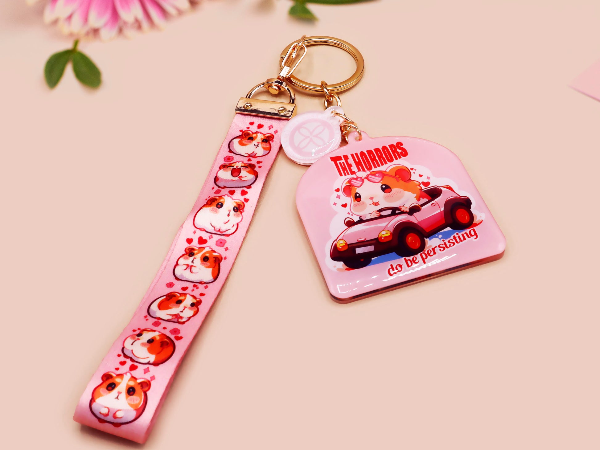 Cute pink keychain and lanyard of an adorable chibi hamster guinea pig in heart sunglasses driving a little pink car with the quote the Horrors do be persisting, with matching mini charm and lanyard of multiple cute fat guinea pig hamsters