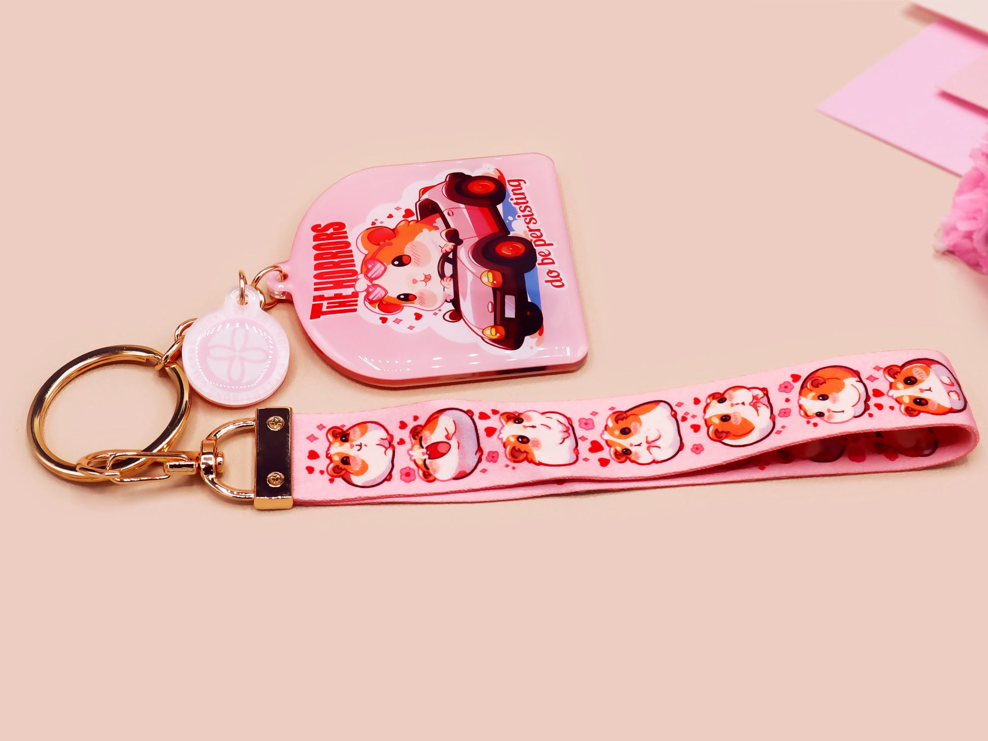 Cute pink keychain and lanyard of an adorable chibi hamster guinea pig in heart sunglasses driving a little pink car with the quote the Horrors do be persisting, with matching mini charm and lanyard of multiple cute fat guinea pig hamsters