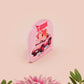 Clear acrylic pin badge with a pink heart-shaped rubber pin back clasp. The design of the pin badge is a cute chibi guinea pig hamster driving a pink car and the quote the horrors do be persisting.
