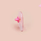 Clear acrylic pin badge with a pink heart-shaped rubber pin back clasp. The design of the pin badge is a cute chibi guinea pig hamster driving a pink car and the quote the horrors do be persisting.