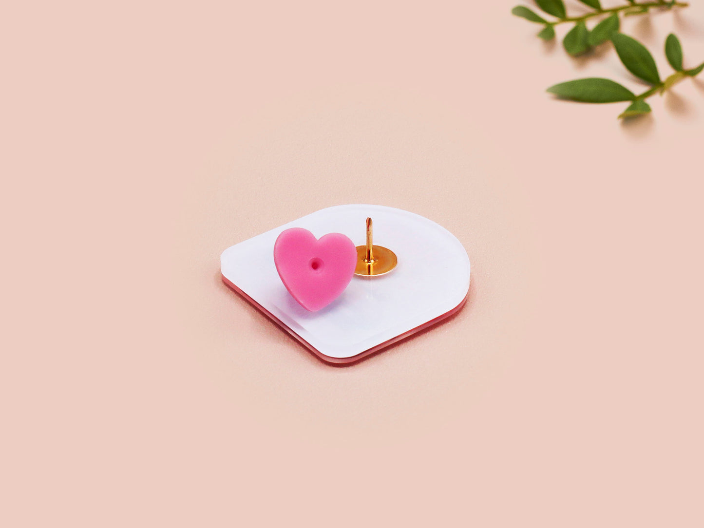Clear acrylic pin badge with a pink heart-shaped rubber pin back clasp. The design of the pin badge is a cute chibi guinea pig hamster driving a pink car and the quote the horrors do be persisting.