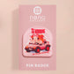 Clear acrylic pin badge with a pink heart-shaped rubber pin back clasp. The design of the pin badge is a cute chibi guinea pig hamster driving a pink car and the quote the horrors do be persisting.