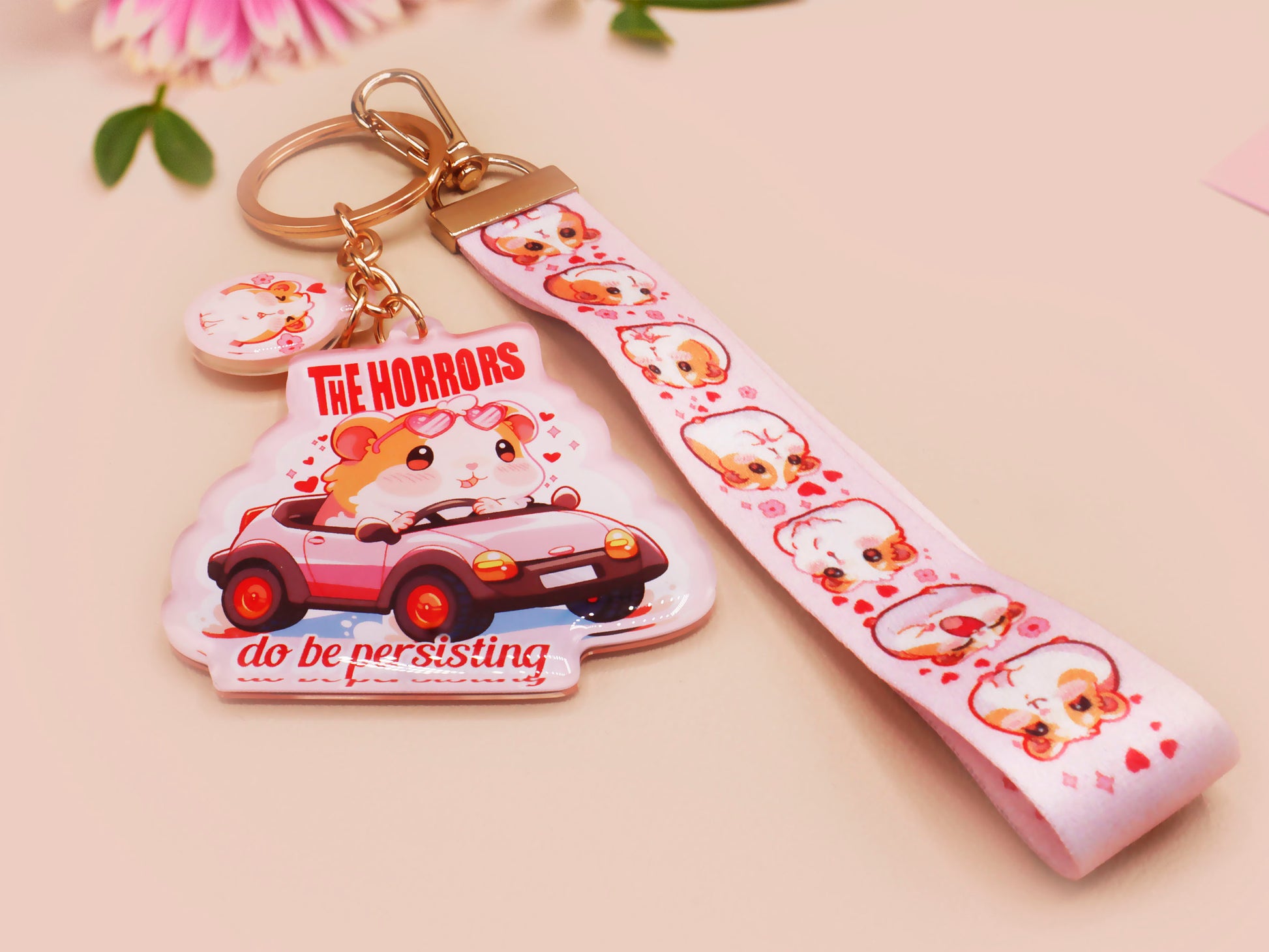 Cute pink keychain and lanyard of an adorable chibi hamster guinea pig in heart sunglasses driving a little pink car with the quote the Horrors do be persisting, with matching mini charm and lanyard of multiple cute fat guinea pig hamsters