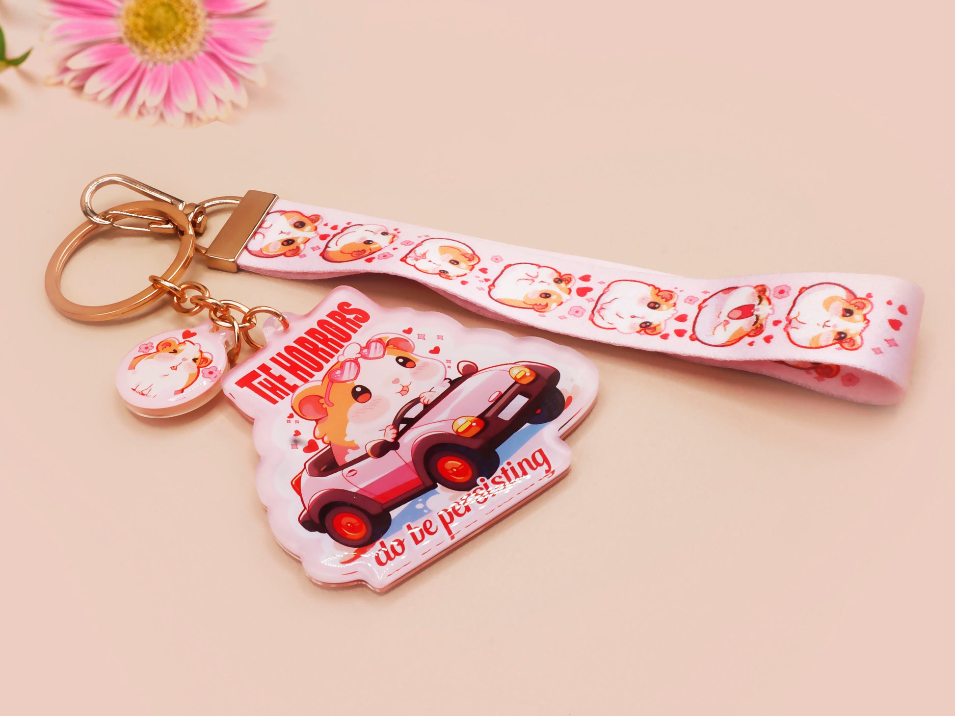 Cute pink keychain and lanyard of an adorable chibi hamster guinea pig in heart sunglasses driving a little pink car with the quote the Horrors do be persisting, with matching mini charm and lanyard of multiple cute fat guinea pig hamsters