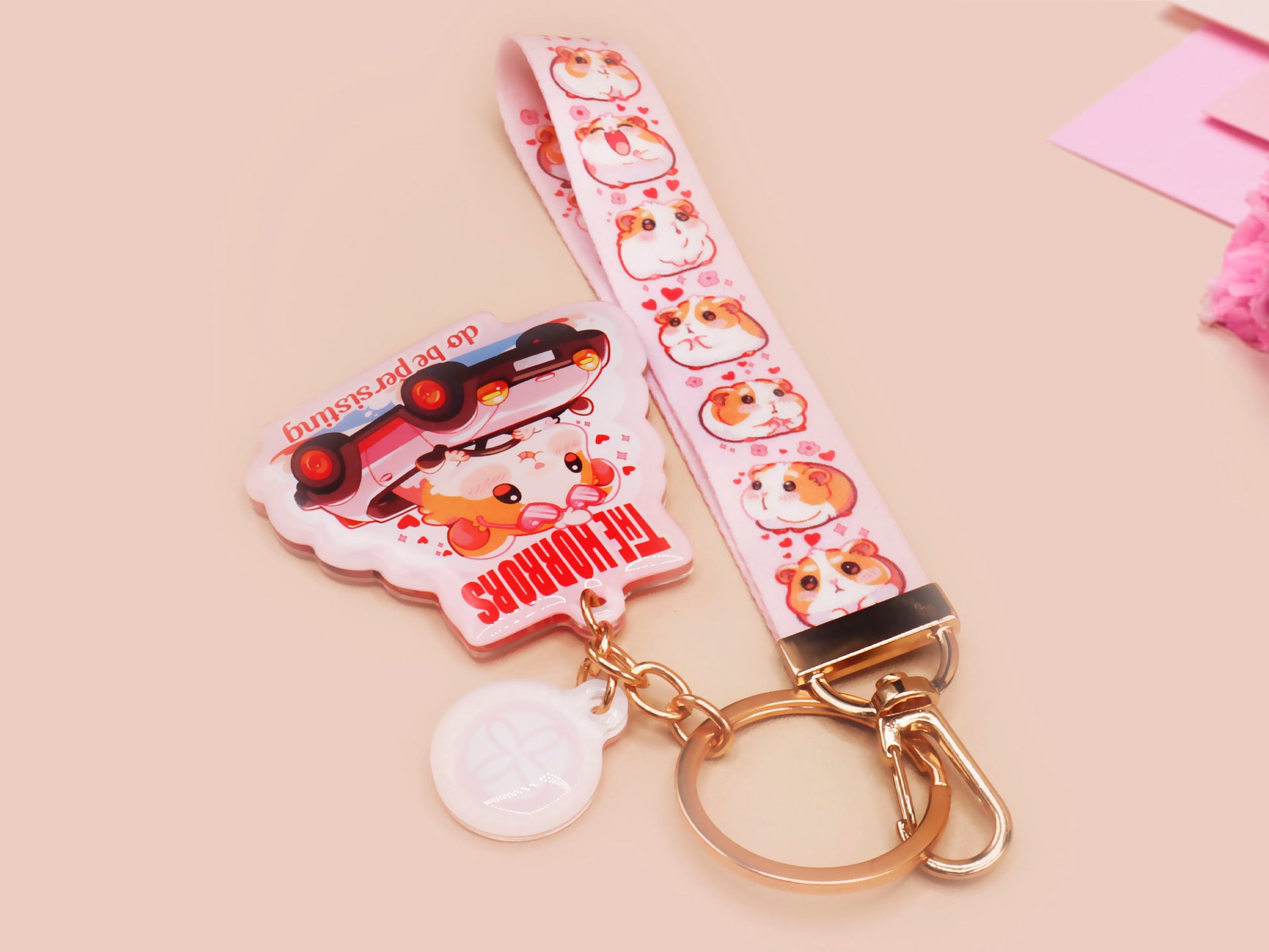 Cute pink keychain and lanyard of an adorable chibi hamster guinea pig in heart sunglasses driving a little pink car with the quote the Horrors do be persisting, with matching mini charm and lanyard of multiple cute fat guinea pig hamsters