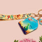 Acrylic epoxy dinosaur keychain with a large acrylic charm of a long necked dinosaur looking up at an incoming asteroid with the quote uh oh, a smaller charm of a cute trex with arm grabbers and a matching hatching baby dinosaur lanyard.
