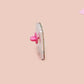 A clear acrylic pin badge with a pink heart-shaped pin back clasp. The design of the pin badge is of a cute long neck dinosur looking at an incoming asteroid with the quote uh oh.