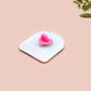 A clear acrylic pin badge with a pink heart-shaped pin back clasp. The design of the pin badge is of a cute long neck dinosur looking at an incoming asteroid with the quote uh oh.