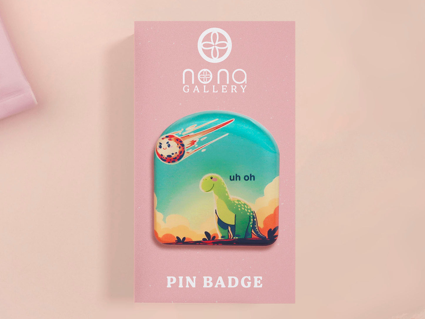 A clear acrylic pin badge with a pink heart-shaped pin back clasp. The design of the pin badge is of a cute long neck dinosur looking at an incoming asteroid with the quote uh oh.