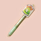 Green ballpoint pen with black ink and a cute chibi cowboy frog design.