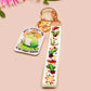 Acrylic epoxy cowboy frog keychain with a large acrylic charm of a cute cowboy frog wearing a stetson hat with the quote well actually this is my first rodeo, a smaller charm of a cute sherrifs badge and a matching cactus and cowboy boots and hats lanyard.