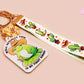 Acrylic epoxy cowboy frog keychain with a large acrylic charm of a cute cowboy frog wearing a stetson hat with the quote well actually this is my first rodeo, a smaller charm of a cute sherrifs badge and a matching cactus and cowboy boots and hats lanyard.