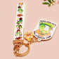 Acrylic epoxy cowboy frog keychain with a large acrylic charm of a cute cowboy frog wearing a stetson hat with the quote well actually this is my first rodeo, a smaller charm of a cute sherrifs badge and a matching cactus and cowboy boots and hats lanyard.