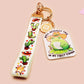 Acrylic epoxy cowboy frog keychain with a large acrylic charm of a cute cowboy frog wearing a stetson hat with the quote well actually this is my first rodeo, a smaller charm of a cute sherrifs badge and a matching cactus and cowboy boots and hats lanyard.
