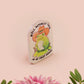 Clear acrylic pin badge with a pink heart-shaped rubber pin back clasp. The design of the pin badge is a cute chibi frog wearing a cowboy hat stetson and the quote well actually this is my first rodeo.