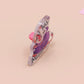 A clear acrylic pin badge with a heart-shaped pin rubber pin back clasp. The design of the pin badge is a cute cartoon screaming possum with the quote why me?!