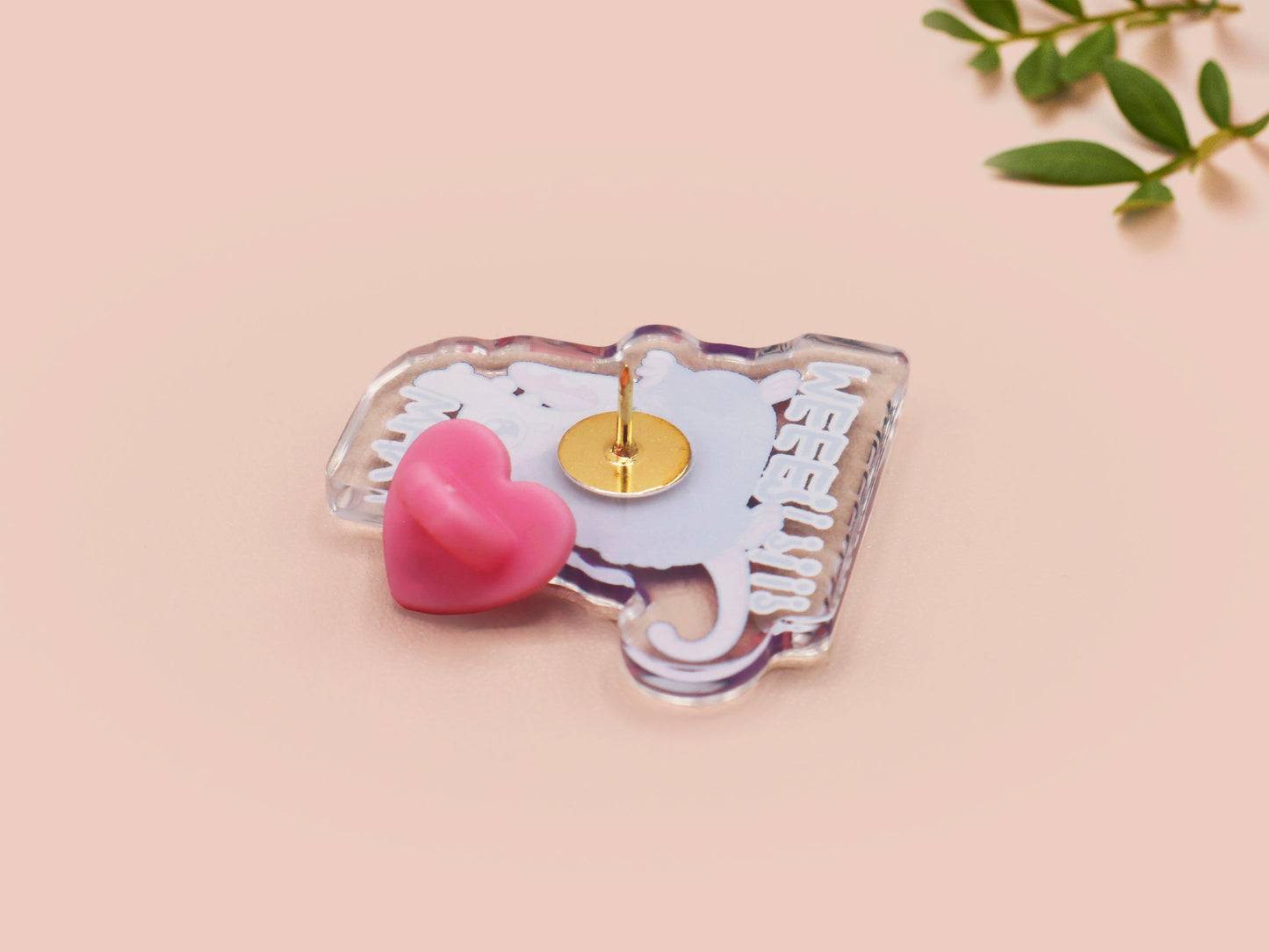 A clear acrylic pin badge with a heart-shaped pin rubber pin back clasp. The design of the pin badge is a cute cartoon screaming possum with the quote why me?!