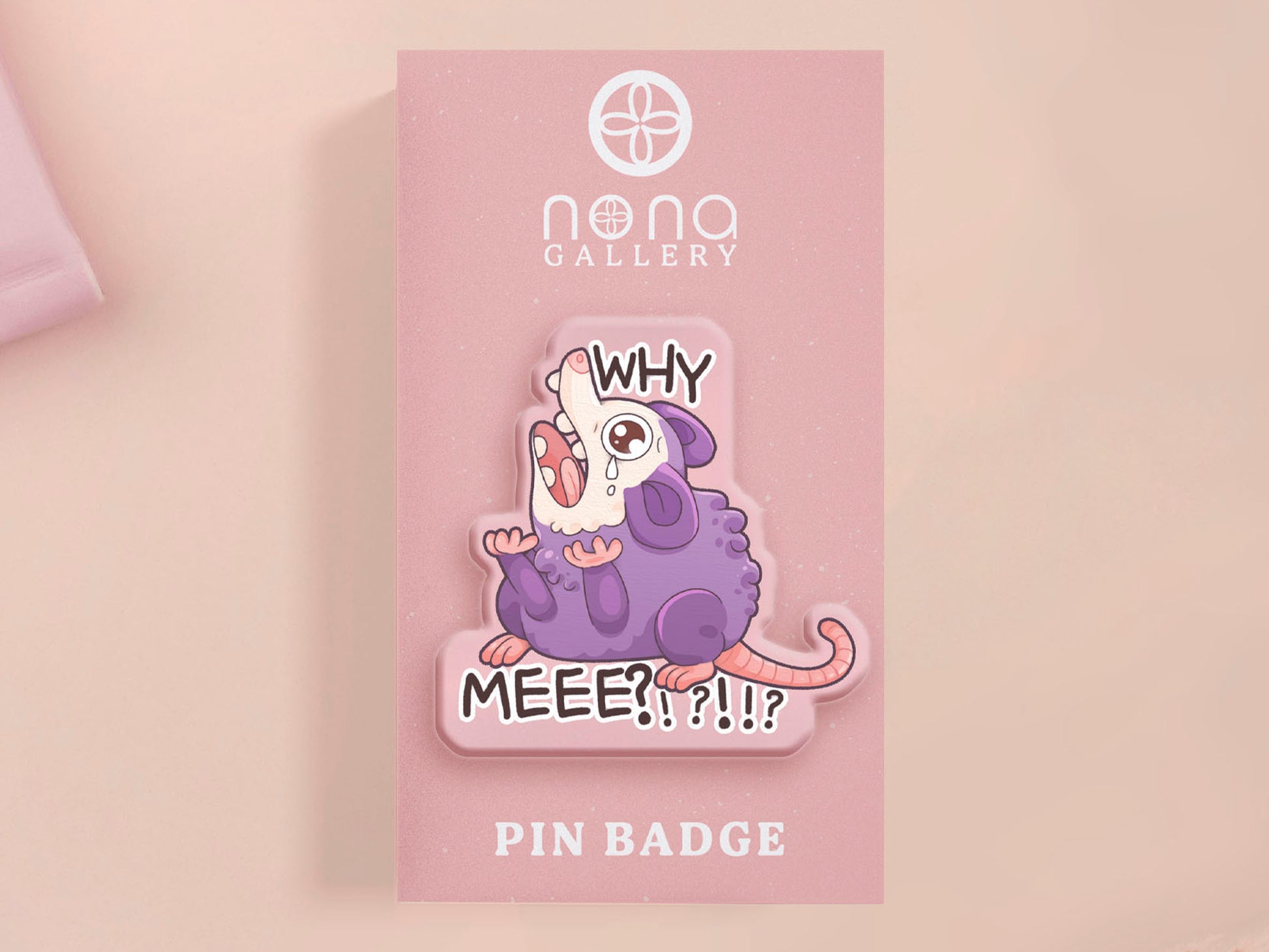 A clear acrylic pin badge with a heart-shaped pin rubber pin back clasp. The design of the pin badge is a cute cartoon screaming possum with the quote why me?!