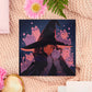 Square art print of a young witch wearing a large glowing witch's hat surrounded by nine cute chibi ghost cats.