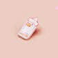 A clear acrylic pin badge with a pink heart-shaped pin back clasp. The design of the pin badge is of a cute chibi goose wearing a paper hat with the quote you silly goose.