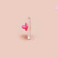A clear acrylic pin badge with a pink heart-shaped pin back clasp. The design of the pin badge is of a cute chibi goose wearing a paper hat with the quote you silly goose.