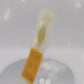 Video showing front and back of the Gold Enamel Talisman Pin with green design and the words Teacher's Talisman sits on a long white and yellow backing card with gold accents. The backing card has details the symbolism of the different design elements of the Talisman pin.