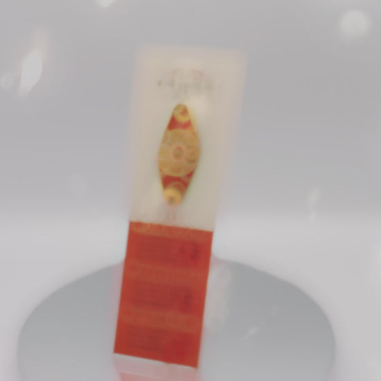 video of front and back of the Gold Enamel Talisman Pin with red design and the words couple's Talisman sits on a long white and red backing card with gold accents. The backing card has details the symbolism of the different design elements of the Talisman pin.
