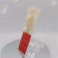 Video of the front and back of the Gold Enamel Talisman Pin with yellow and red design and the words Cosplayer's Talisman sits on a long white and red backing card with gold accents. The backing card has details the symbolism of the different design elements of the Talisman pin.