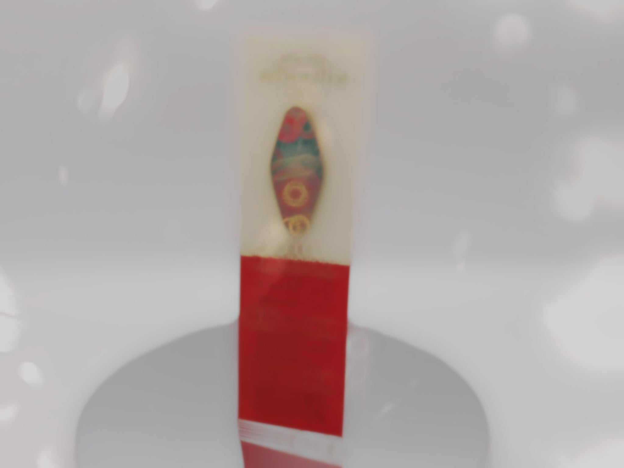 Video of front and back of the Gold Enamel Talisman Pin with red and blue design and the words RPG Talisman sits on a long white and red backing card with gold accents. The backing card has details the symbolism of the different design elements of the Talisman pin.