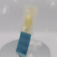 Video of the front and back of the Gold Enamel Talisman Pin with yellow design and the words Father's Talisman sits on a long white and blue backing card with gold accents. The backing card has details the symbolism of the different design elements of the Talisman pin.