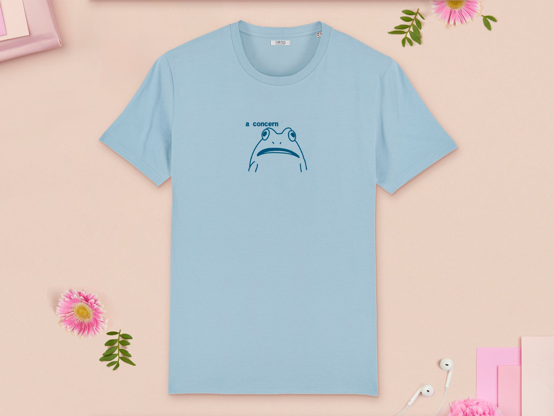 A blue crew neck short sleeve t-shirt, with an embroidered blue thread design of cute confused looking frog with the text a concern.