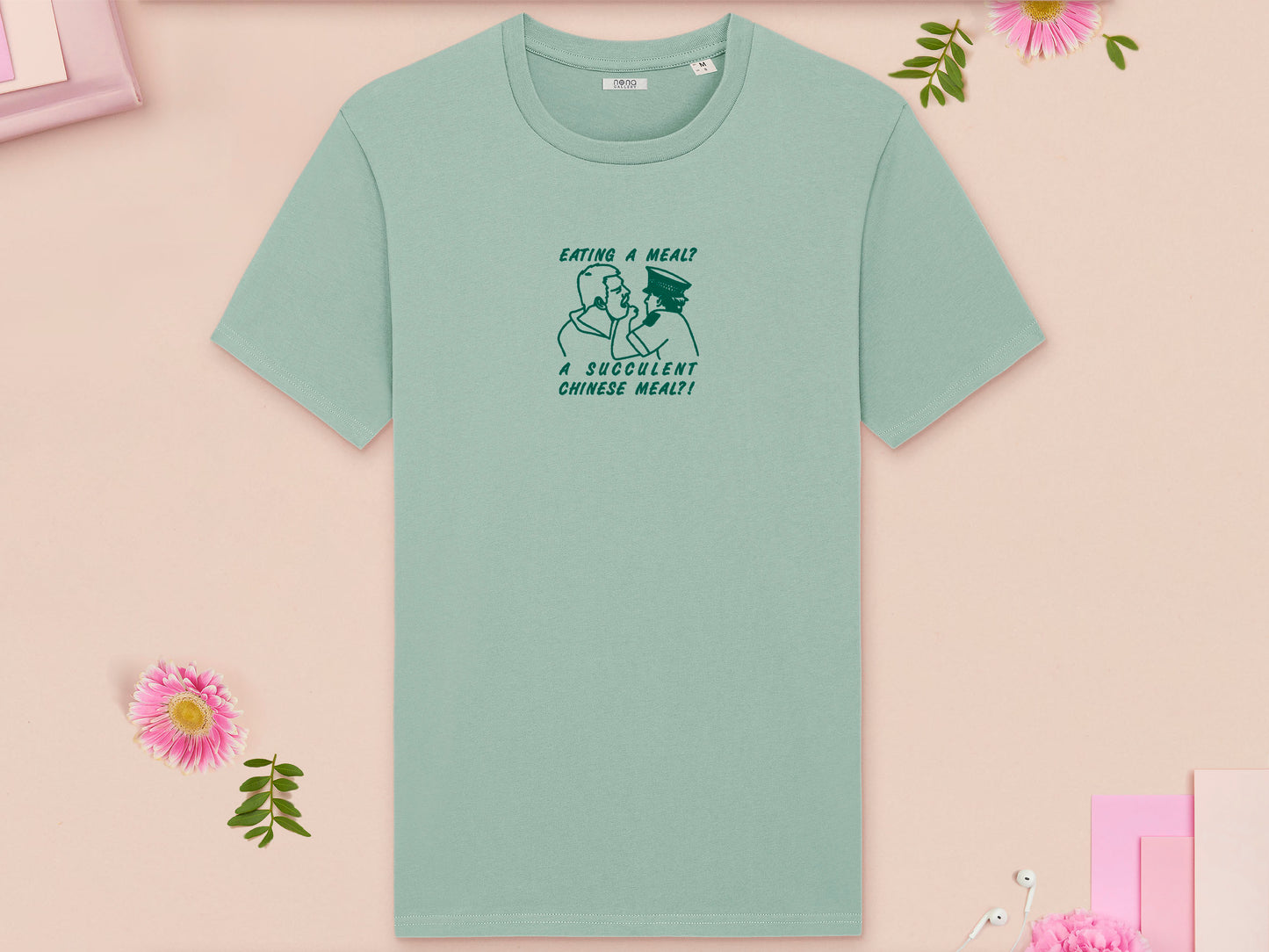 A green crew neck short sleeve t-shirt, with an embroidered green thread design of the viral democracy manifest video of Charles Dozsa being arrested by a policeman with the text reading Eating A Meal? A Succulent Chinese Meal?!