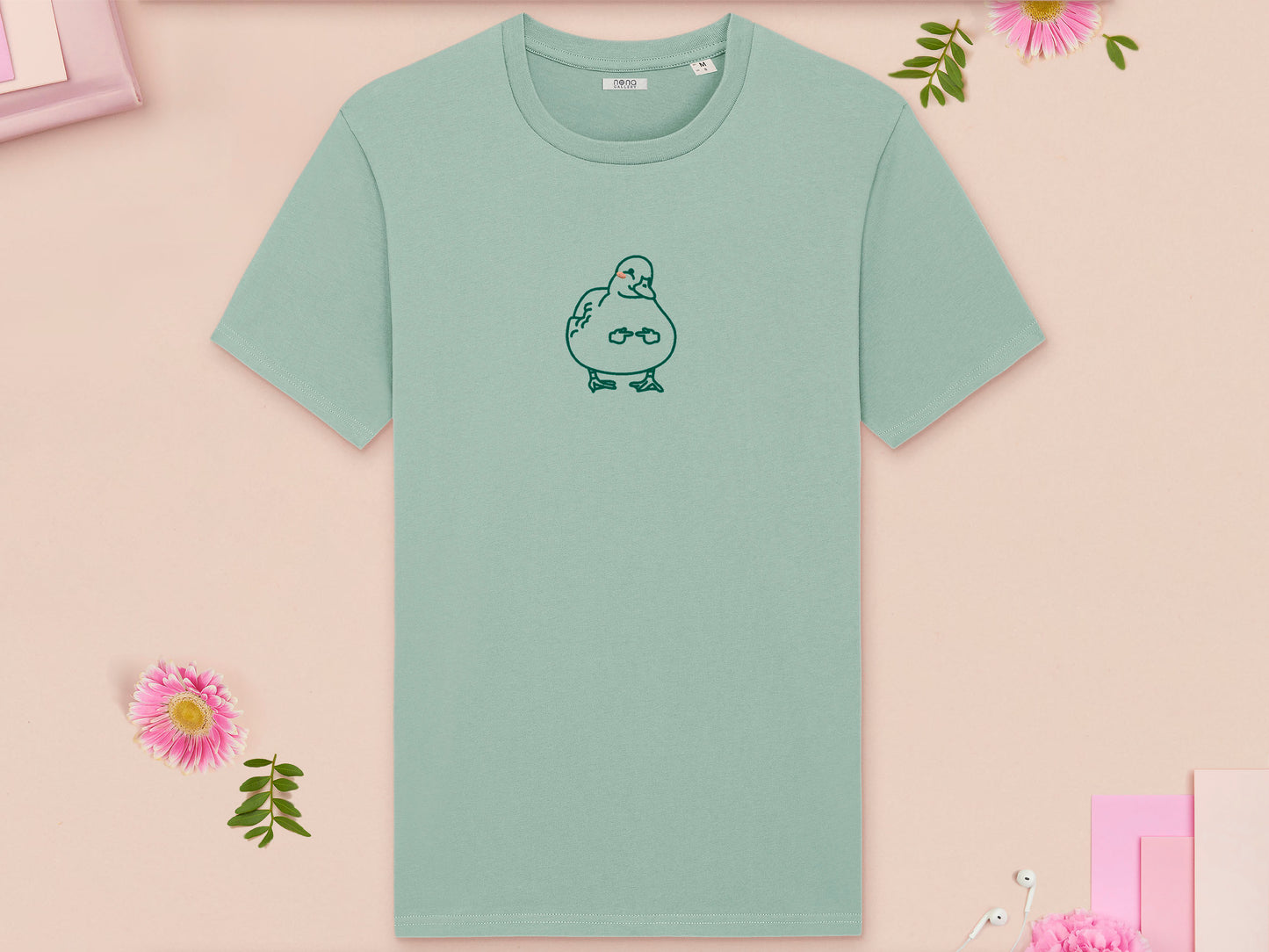 A green crew neck short sleeve t-shirt, with an embroidered green thread design of cute blushing duck with the for me finger hand emoji symbols