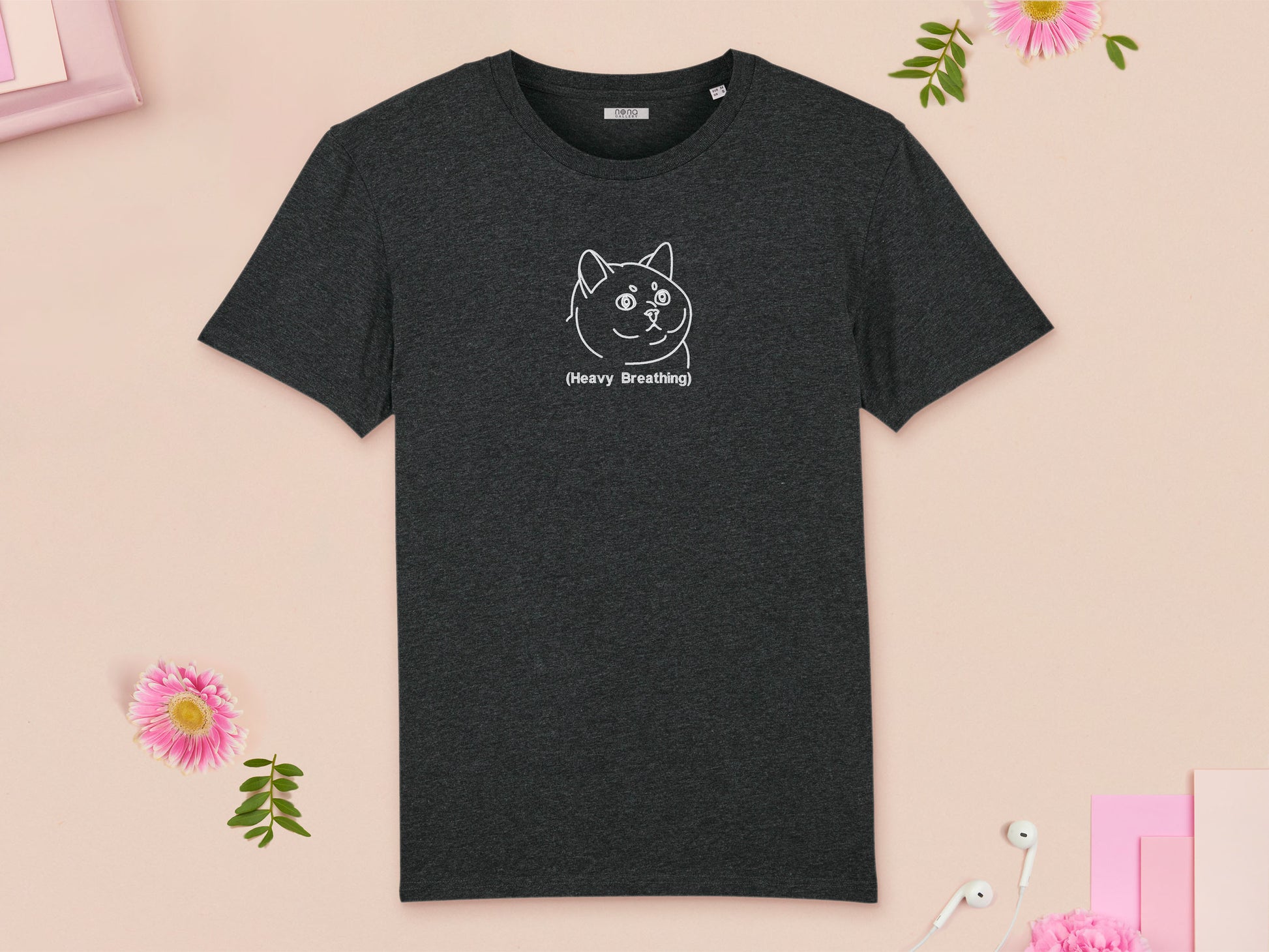 A grey crew neck short sleeve t-shirt, with an embroidered black thread design of cute fat cat portrait with text underneath saying (Heavy Breathing)