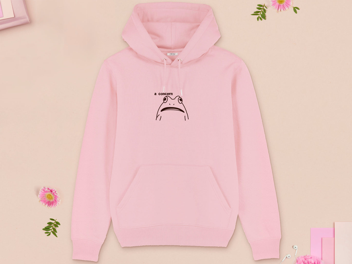 A pink long sleeve fleece hoodie, with an embroidered brown thread design of cute confused looking frog with the text a concern.