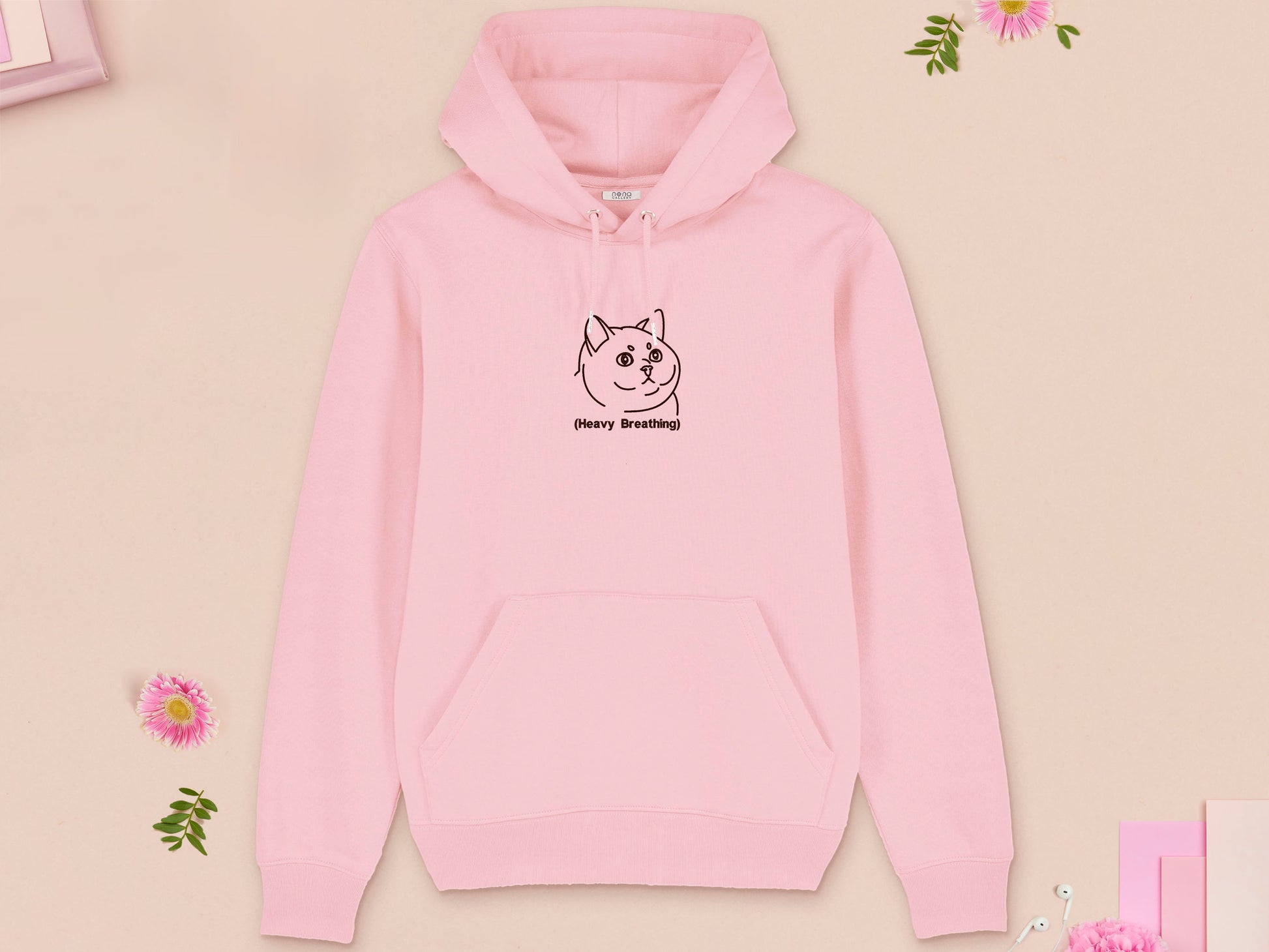 A pink long sleeve fleece hoodie, with an embroidered brown thread design of cute fat cat portrait with text underneath saying (Heavy Breathing)
