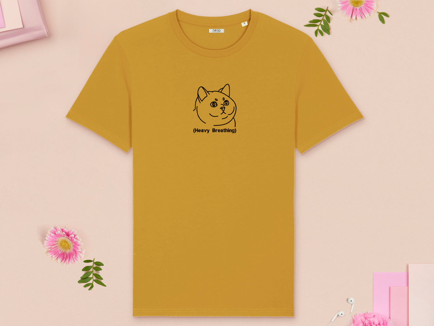 A yellow crew neck short sleeve t-shirt, with an embroidered black thread design of cute fat cat portrait with text underneath saying (Heavy Breathing)